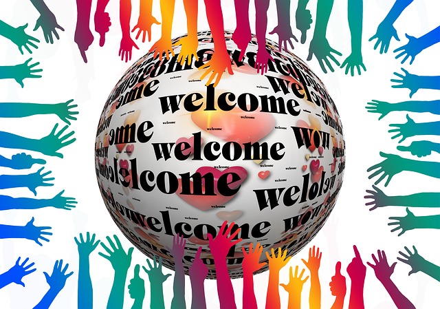 Una multitud de manos extendiéndose hacia una esfera en la que se lee "welcome"