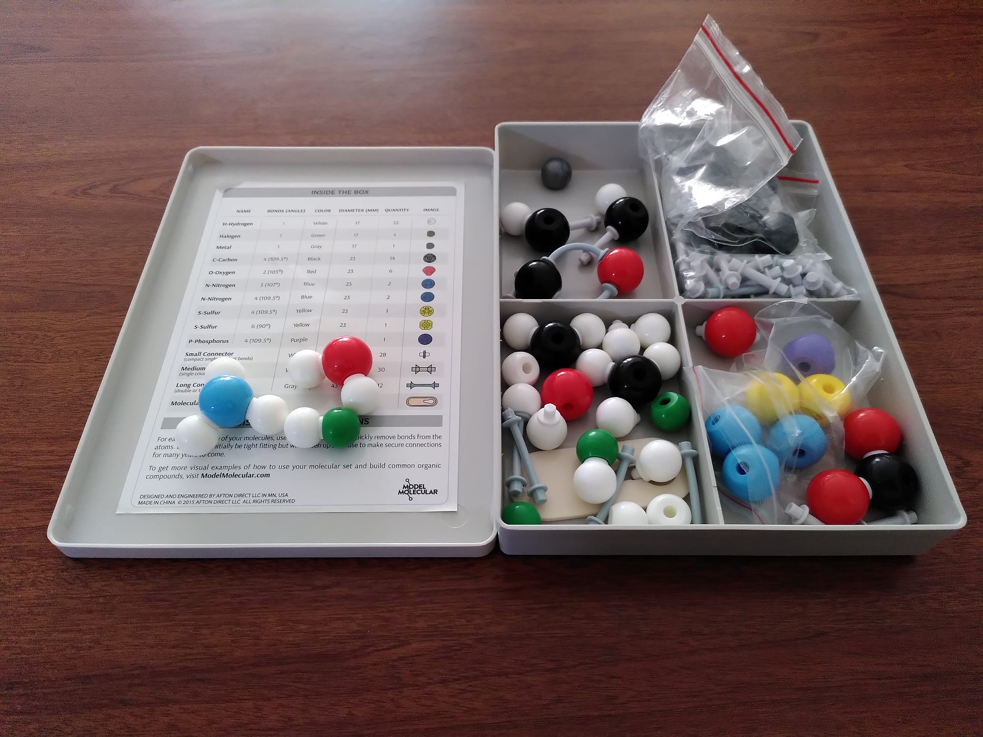 Caja de modelos moleculares para estudiantes. Cuenta con una colección de esferas de colores de pequeño tamaño y enlaces.