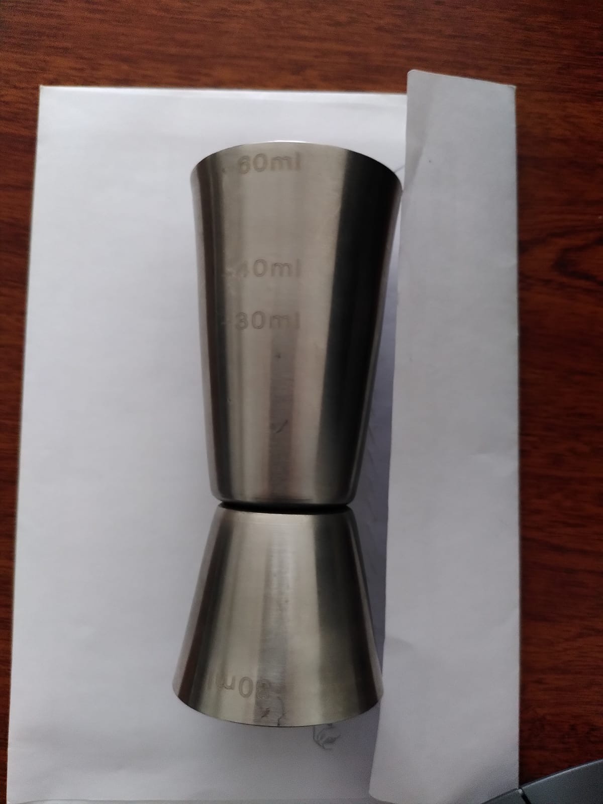 Vaso medidor de cócteles de acero inoxidable. En realidad son dos vasos unidos por su base, uno de 30 mL y otro de 60 mL.